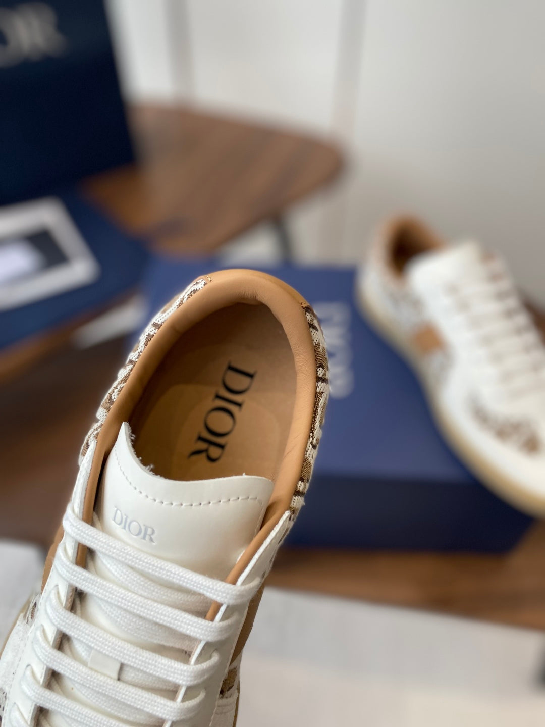 Dior unisex sneaker showing white tongue with DIOR logo patch and tan lining