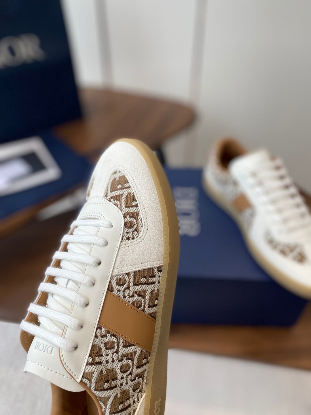 Side profile Dior unisex sneaker in white with tan monogram panel and lace-up