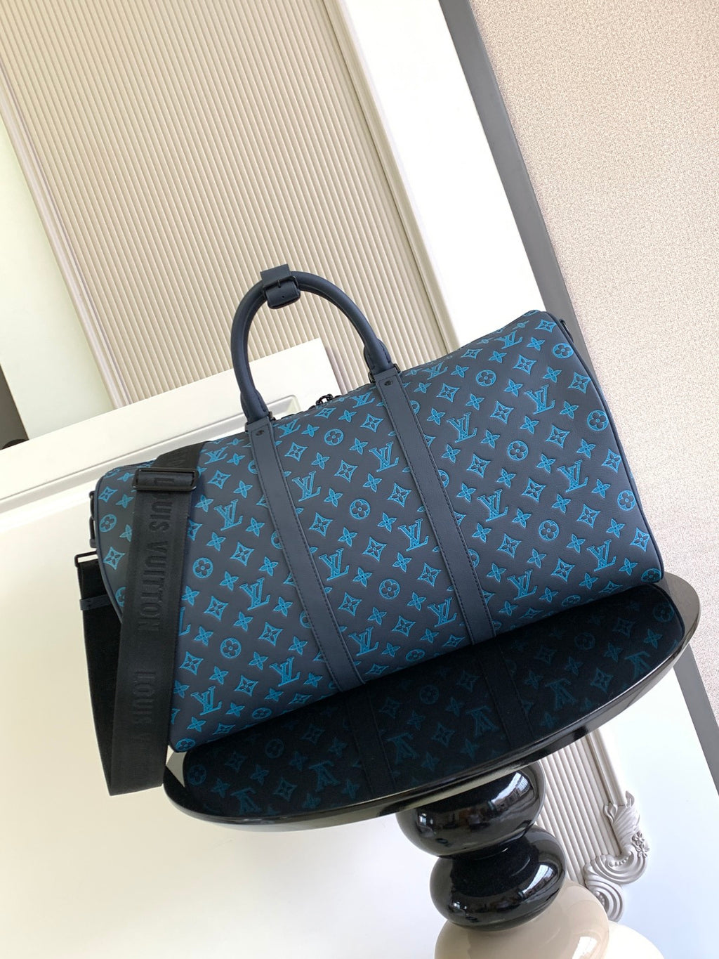 Blue monogram duffel bag with top handles and hanging tag