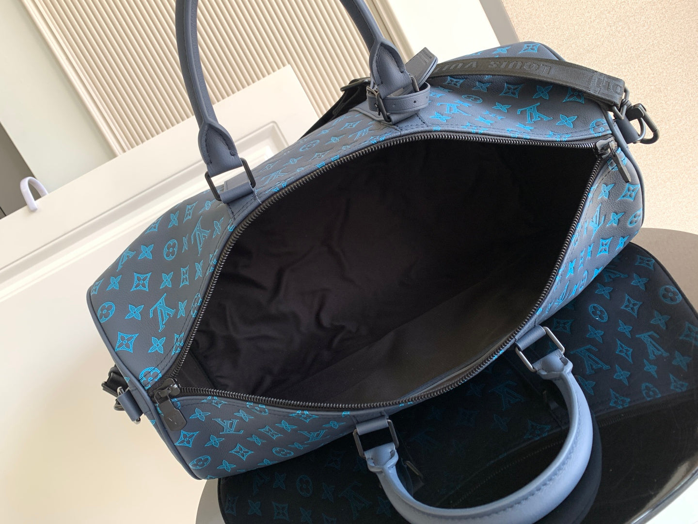 Blue monogram duffel bag with open top and dark inner lining