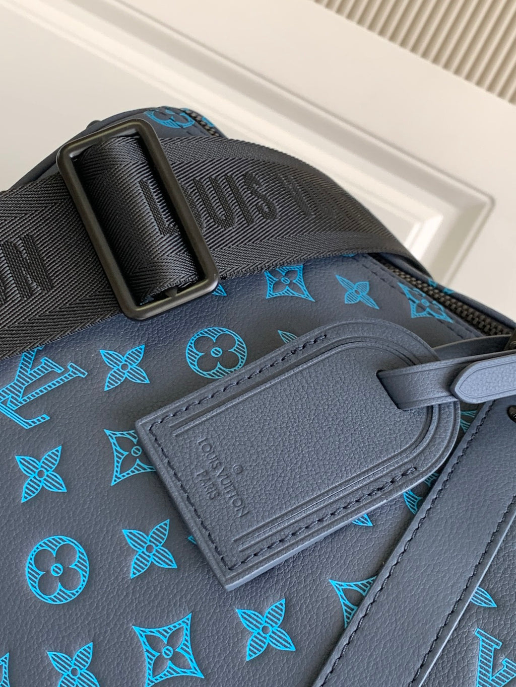 Blue monogram duffel bag close-up of embossed leather patch and strap