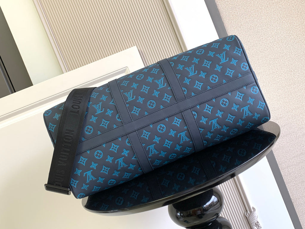 Blue monogram duffel bag with front panel and top handles, side view