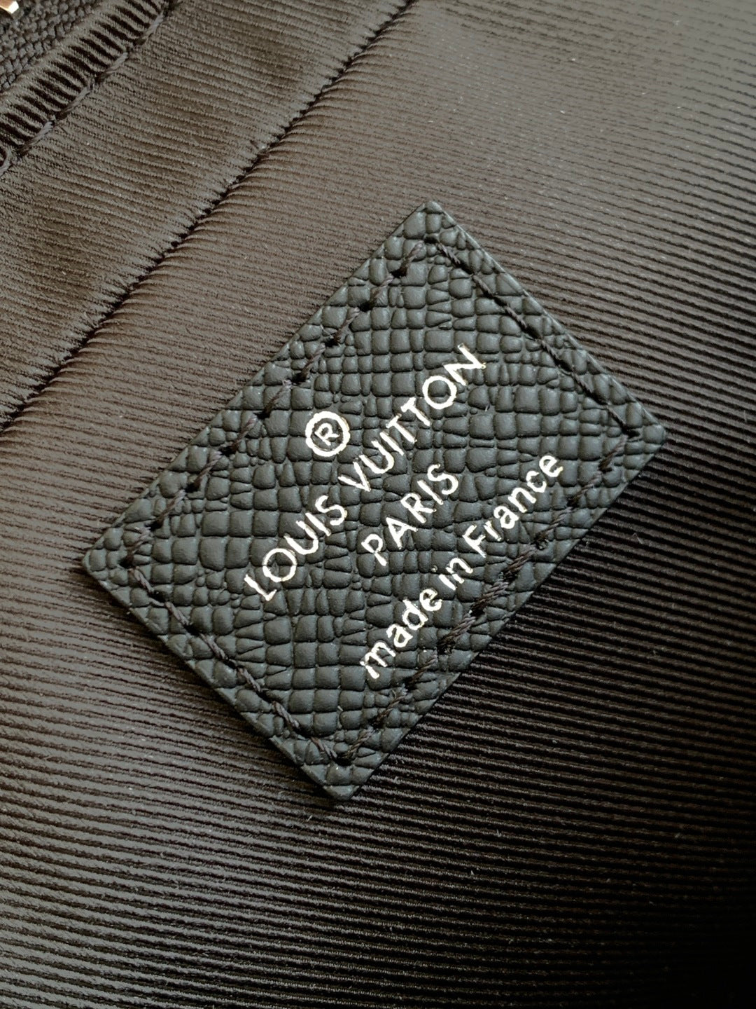 Louis Vuitton bag, black leather care label with Louis Vuitton Paris text