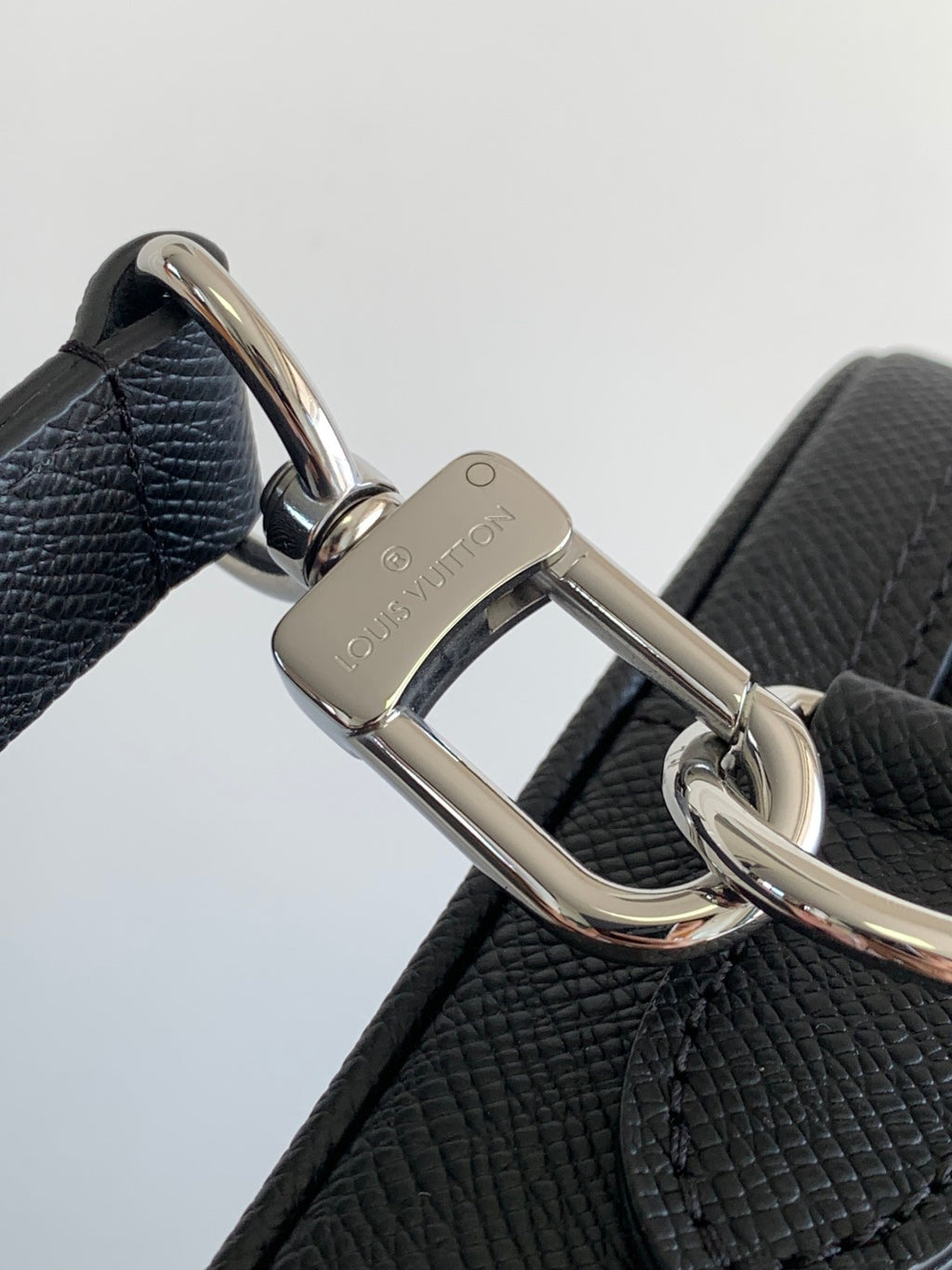 Louis Vuitton bag, dark leather strap attachment with polished D-ring and logo plate