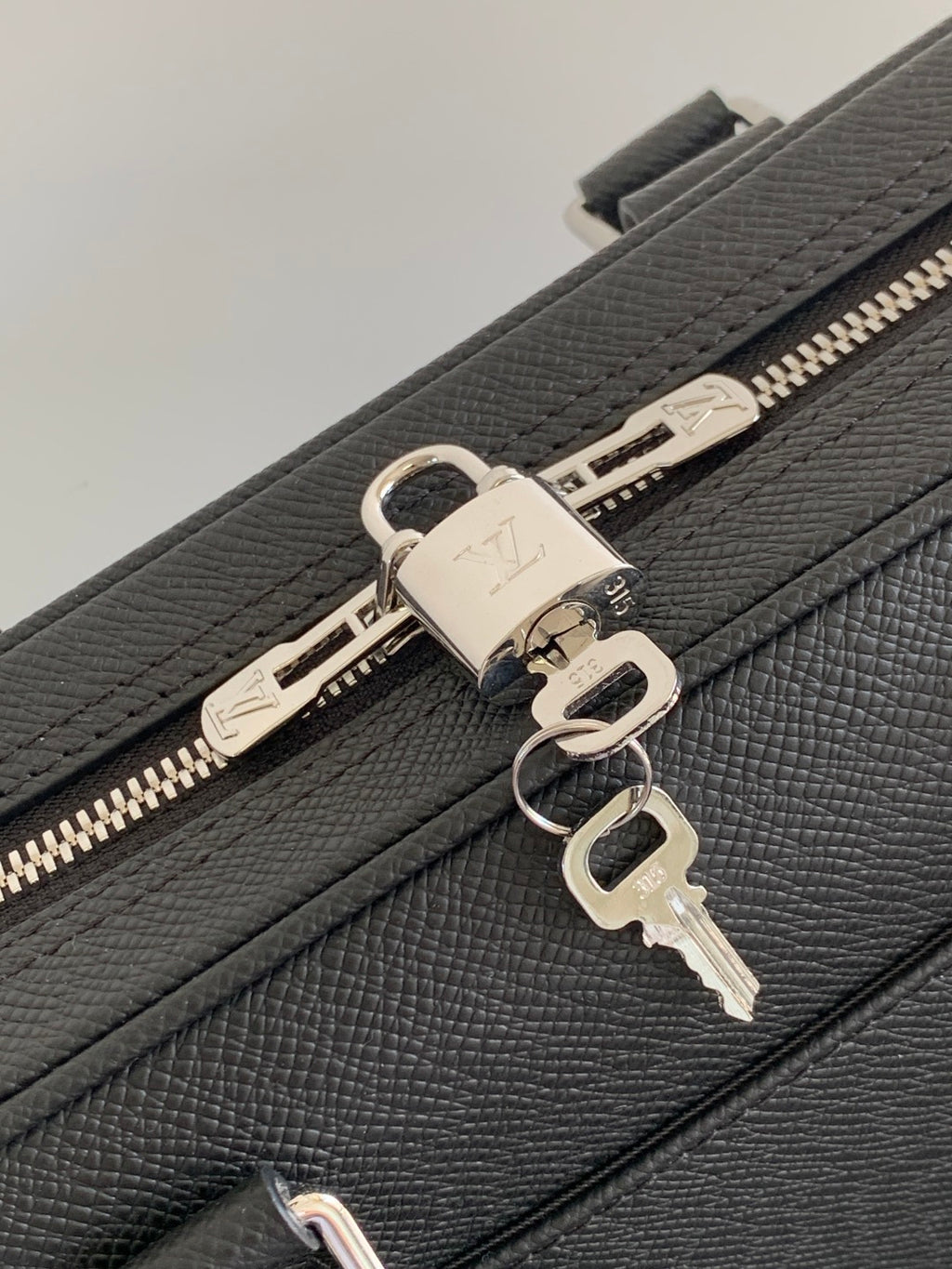 Louis Vuitton bag, dark leather zipper with metal pulls and key-ring hardware