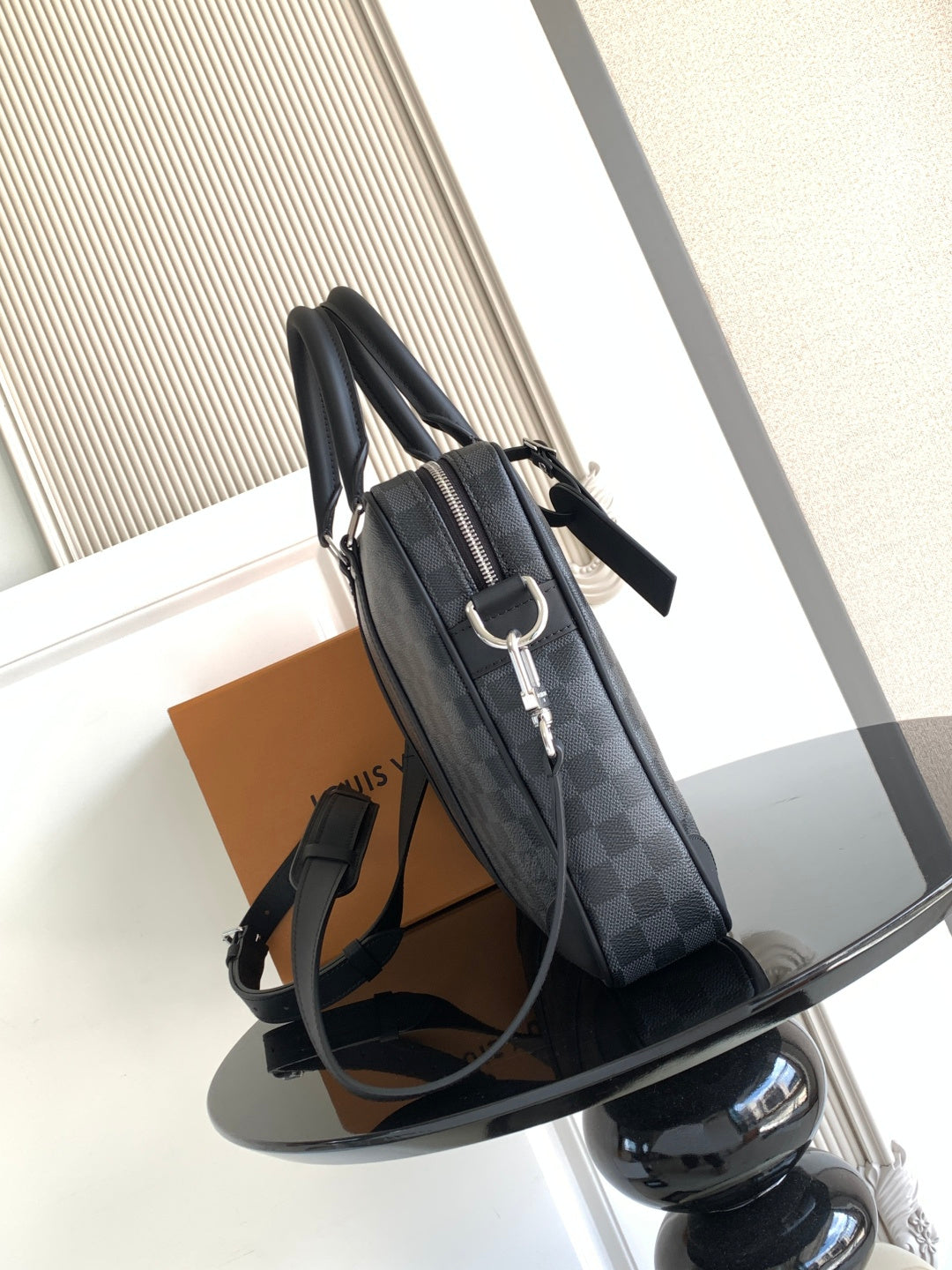 Louis Vuitton checkered bag with shoulder strap and silver buckle hardware, dark gray
