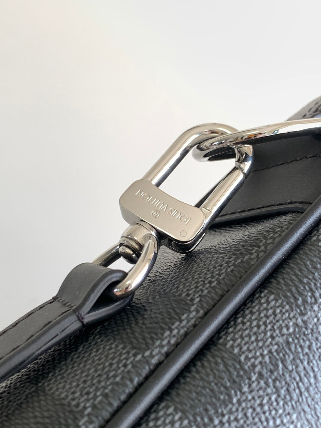Louis Vuitton bag side hardware ring with metal clasp, dark gray checkered texture