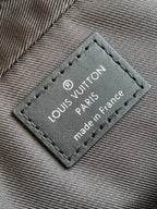 Louis Vuitton label patch on bag with "made in France" text, dark gray leather