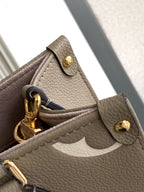 Louis Vuitton bag close-up of gold hardware, clasp tab, and textured leather side.