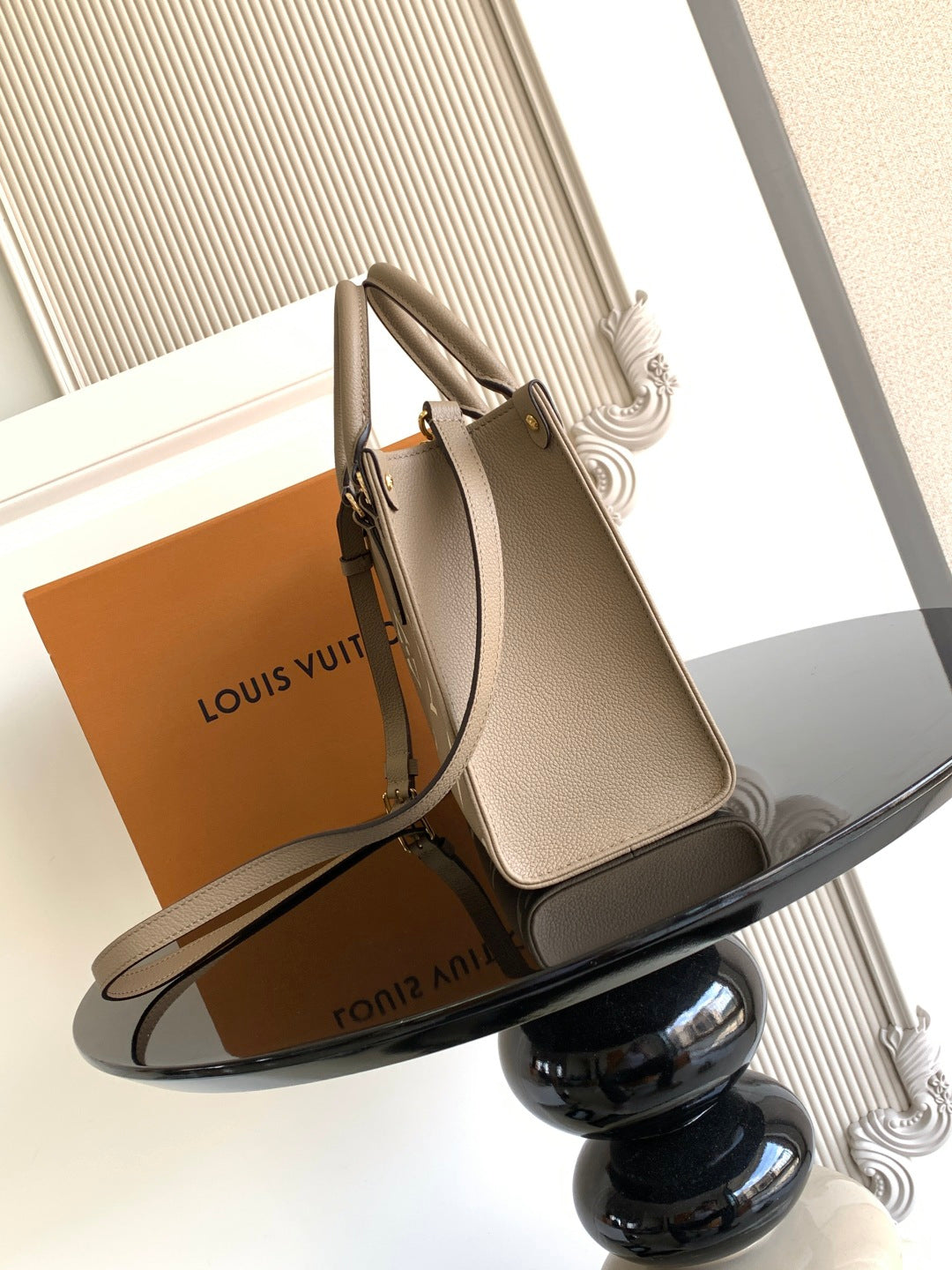 Louis Vuitton bag with monogram detail, rolled top handles, and side profile view.