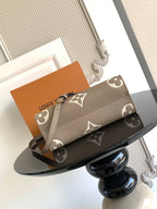 Louis Vuitton bag with monogram canvas pattern and long strap, shown folded on tray.
