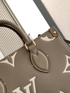 Louis Vuitton bag close-up of monogram strap patch and leather trim on gray-beige.