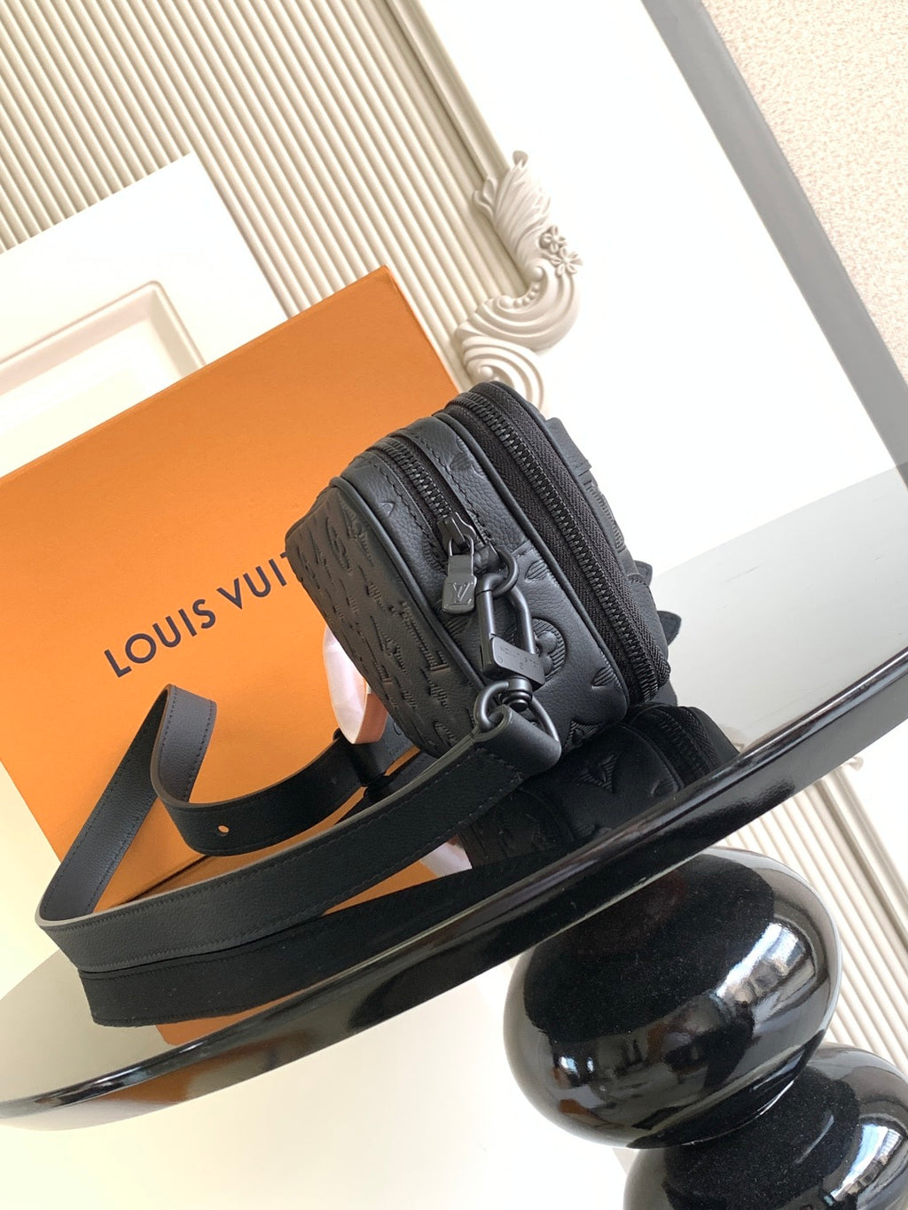 Louis Vuitton monogram crossbody bag with dark strap, top handle, and round hardware
