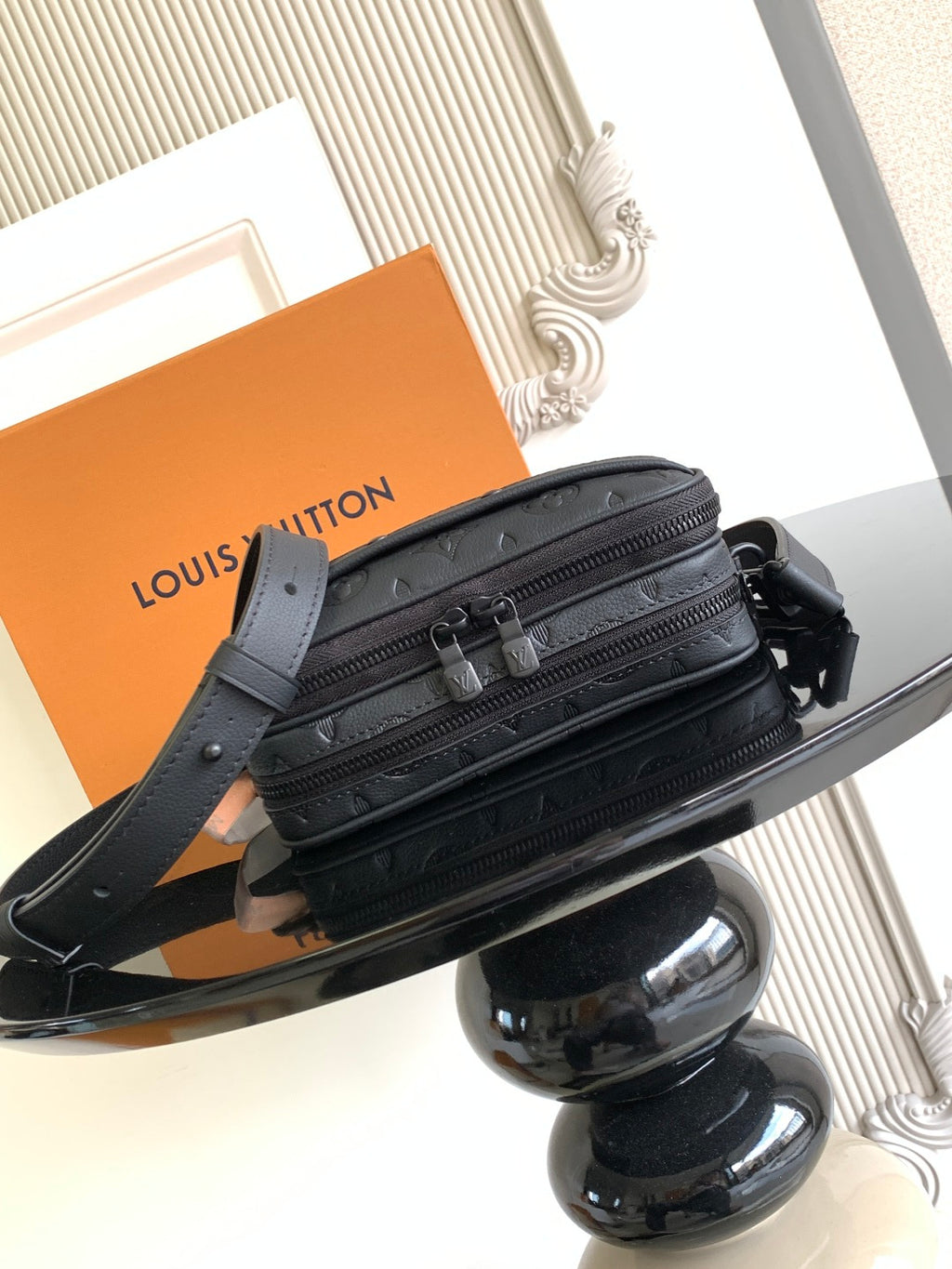 Louis Vuitton monogram crossbody bag showing front pockets, dark strap, and zipper details