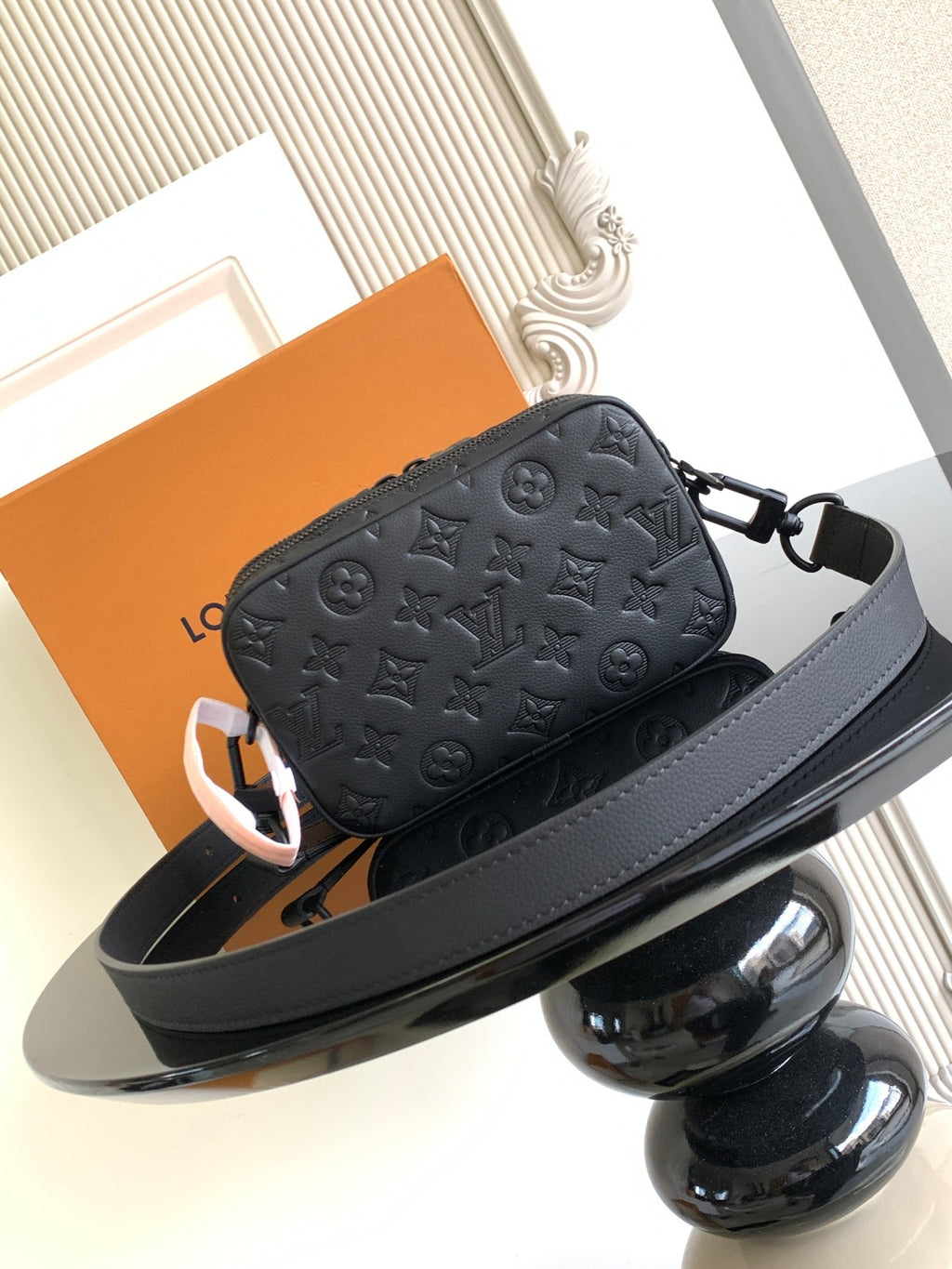 Louis Vuitton monogram crossbody bag with dark leather strap and front zipper closure