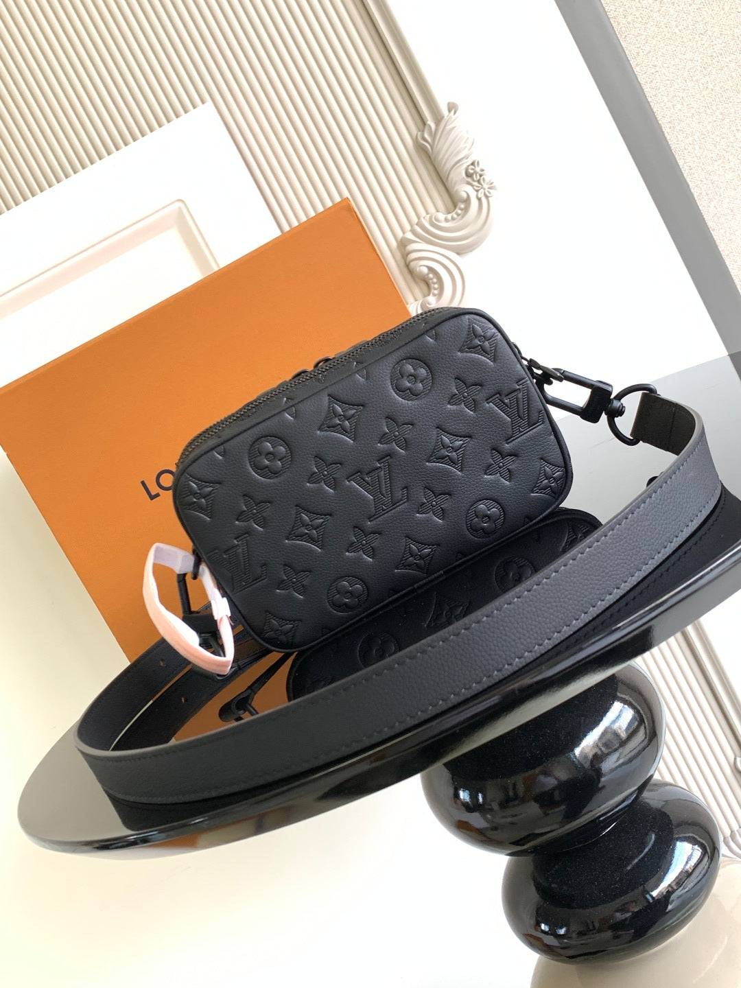 Louis Vuitton monogram crossbody bag with dark leather strap and front zipper closure
