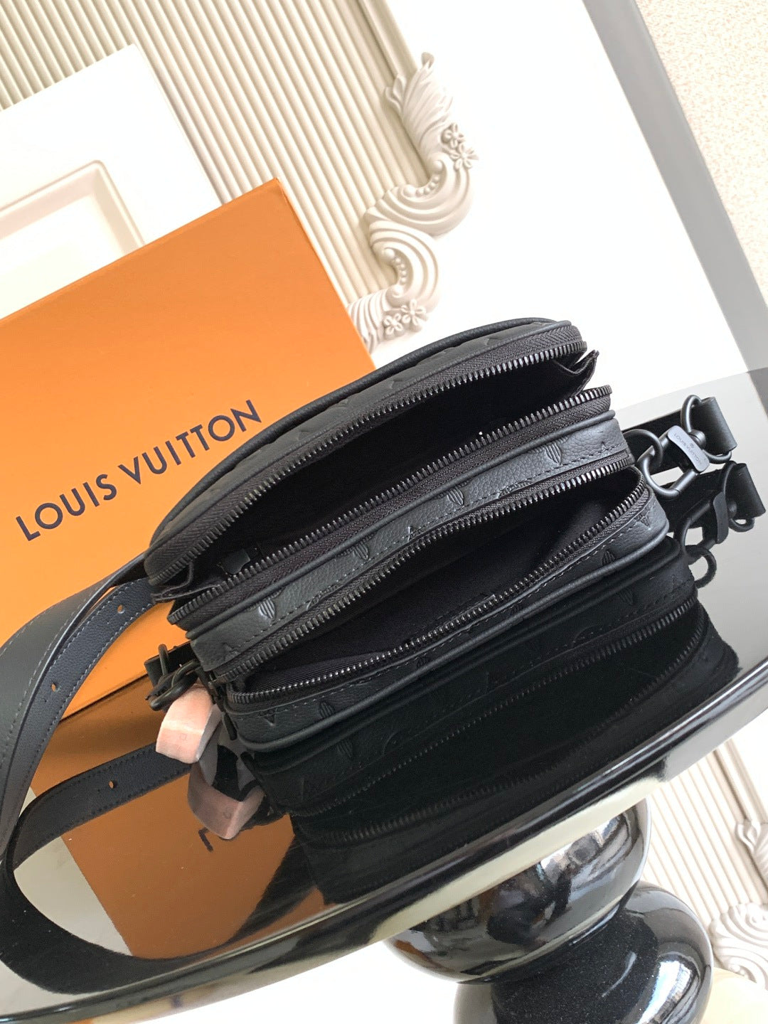 Louis Vuitton monogram crossbody bag side view with layered zippers and dark strap