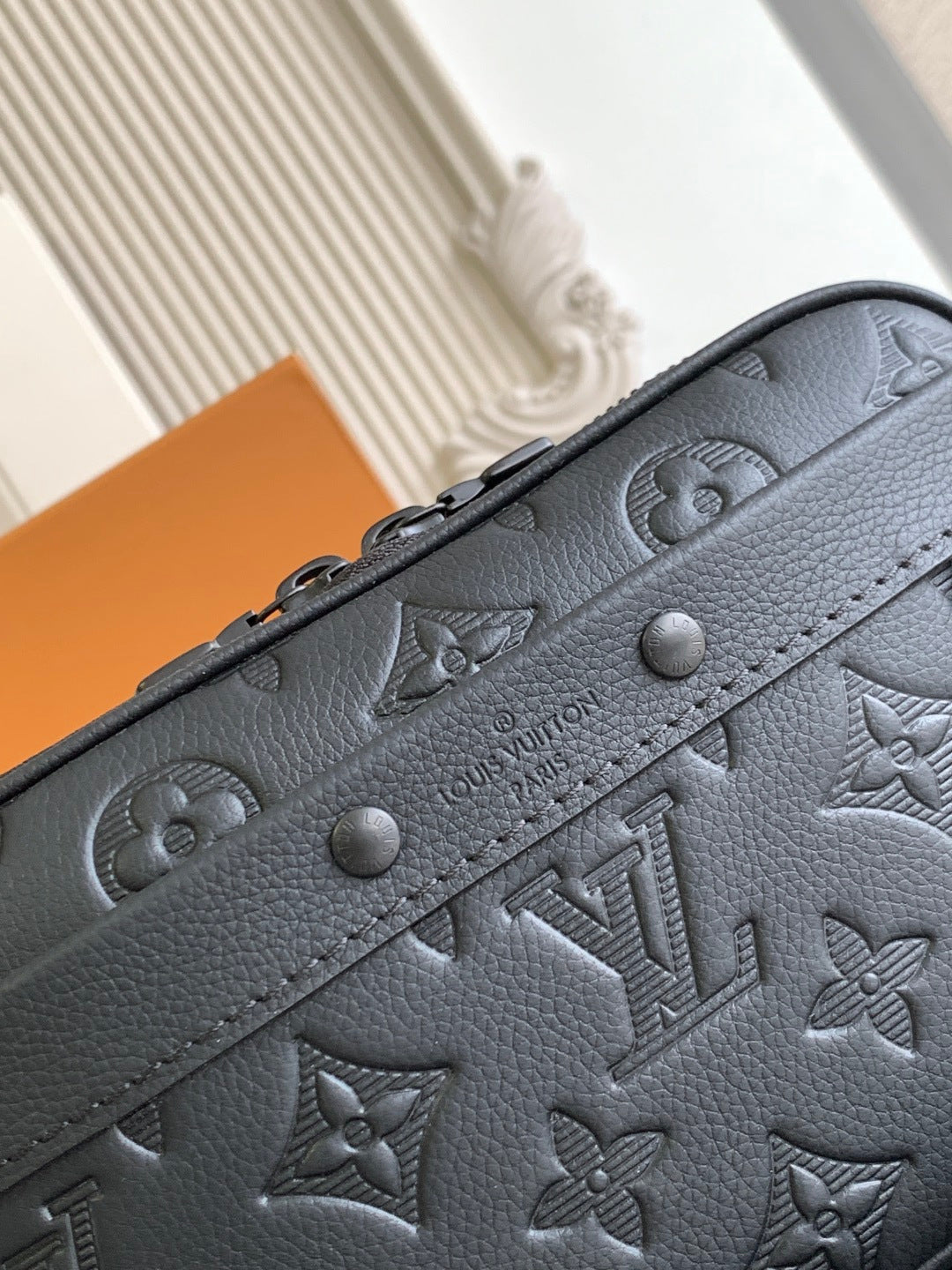 Louis Vuitton monogram crossbody bag front in dark leather with embossed motifs and studs
