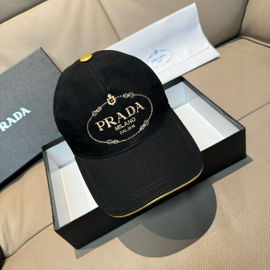 Black baseball cap with gold Prada Milano logo patch and curved brim trim.
