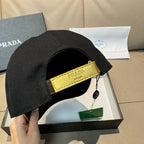 Black baseball cap with yellow interior strap and Prada logo patch near side.