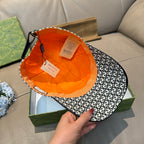 Gucci cap with black-and-white GG monogram pattern, inside lining shown in orange.