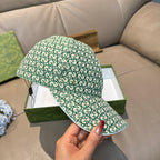 Gucci green GG monogram cap with curved brim, held near the side
