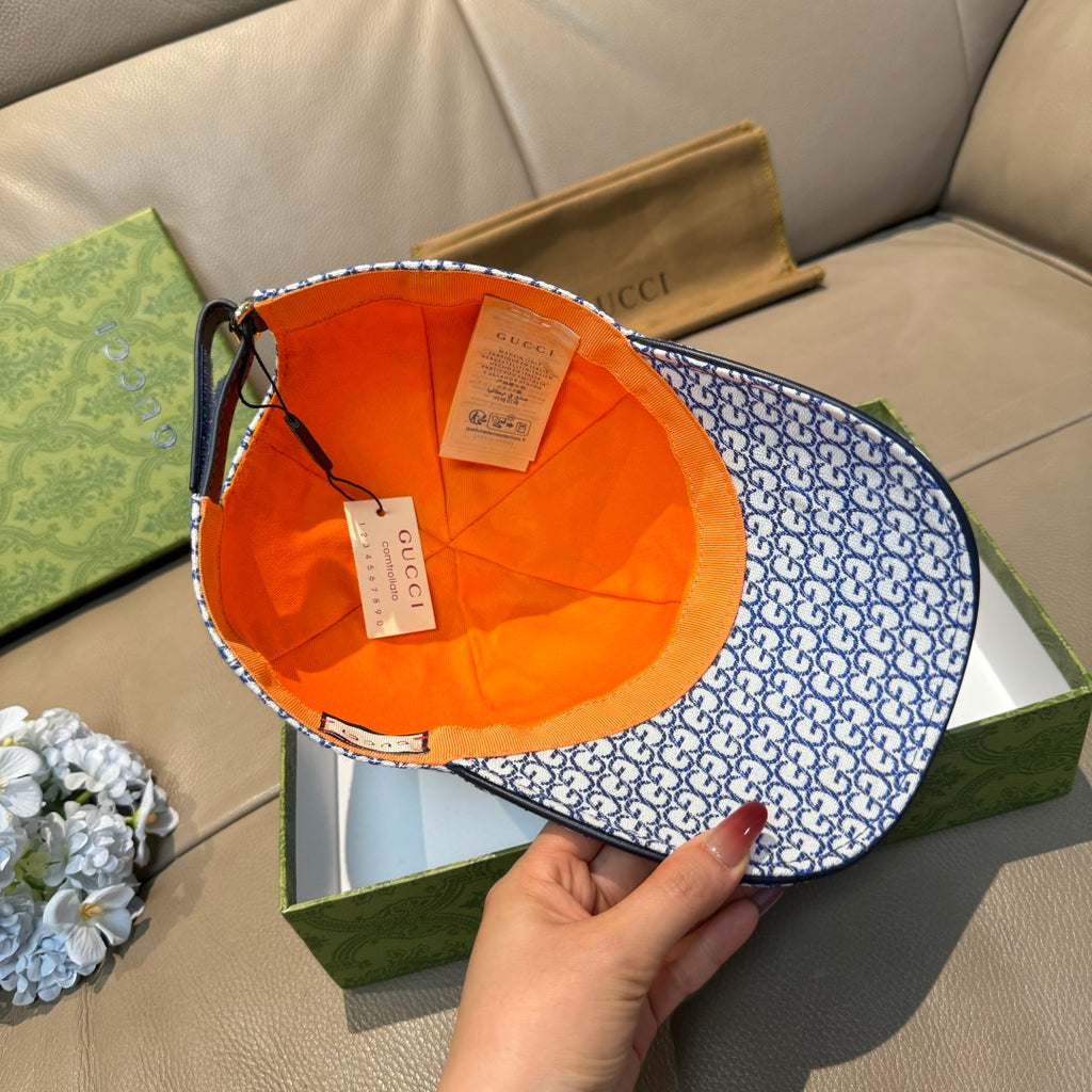 Gucci blue GG-pattern cap with orange interior lining shown from inside.