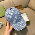 Gucci blue GG-pattern baseball cap with small black top button, side view.