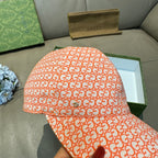Orange GG-pattern baseball cap with curved brim, top and front close-up