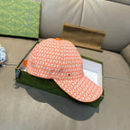 Orange GG-pattern baseball cap, angled side view with curved brim