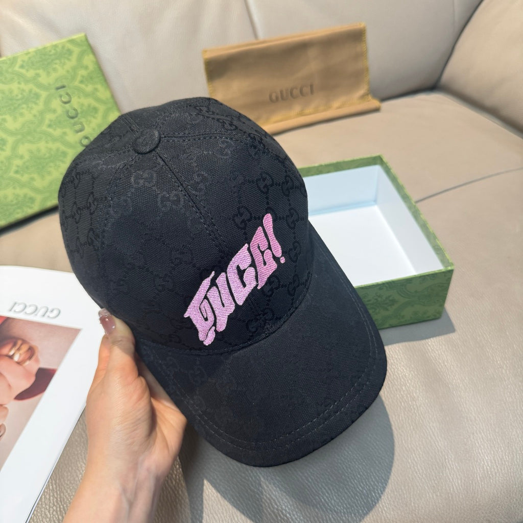 Black Gucci baseball cap held up, GG pattern with pink logo patch and curved brim