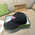 Black Gucci baseball cap with allover GG pattern and pink logo patch on front