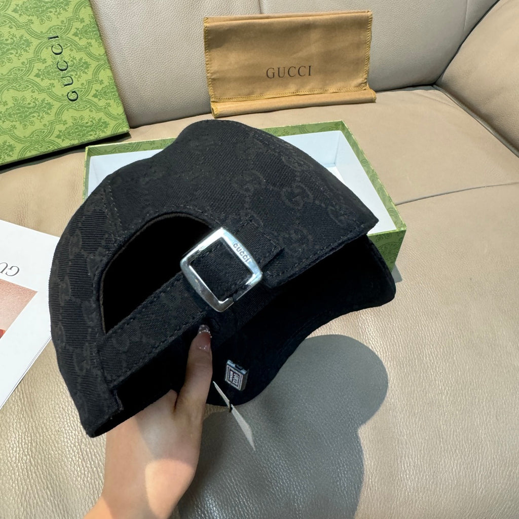Black Gucci baseball cap strap with metal buckle and GG monogram fabric.