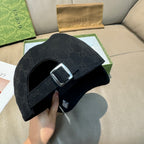 Black Gucci baseball cap strap with metal buckle and GG monogram fabric.