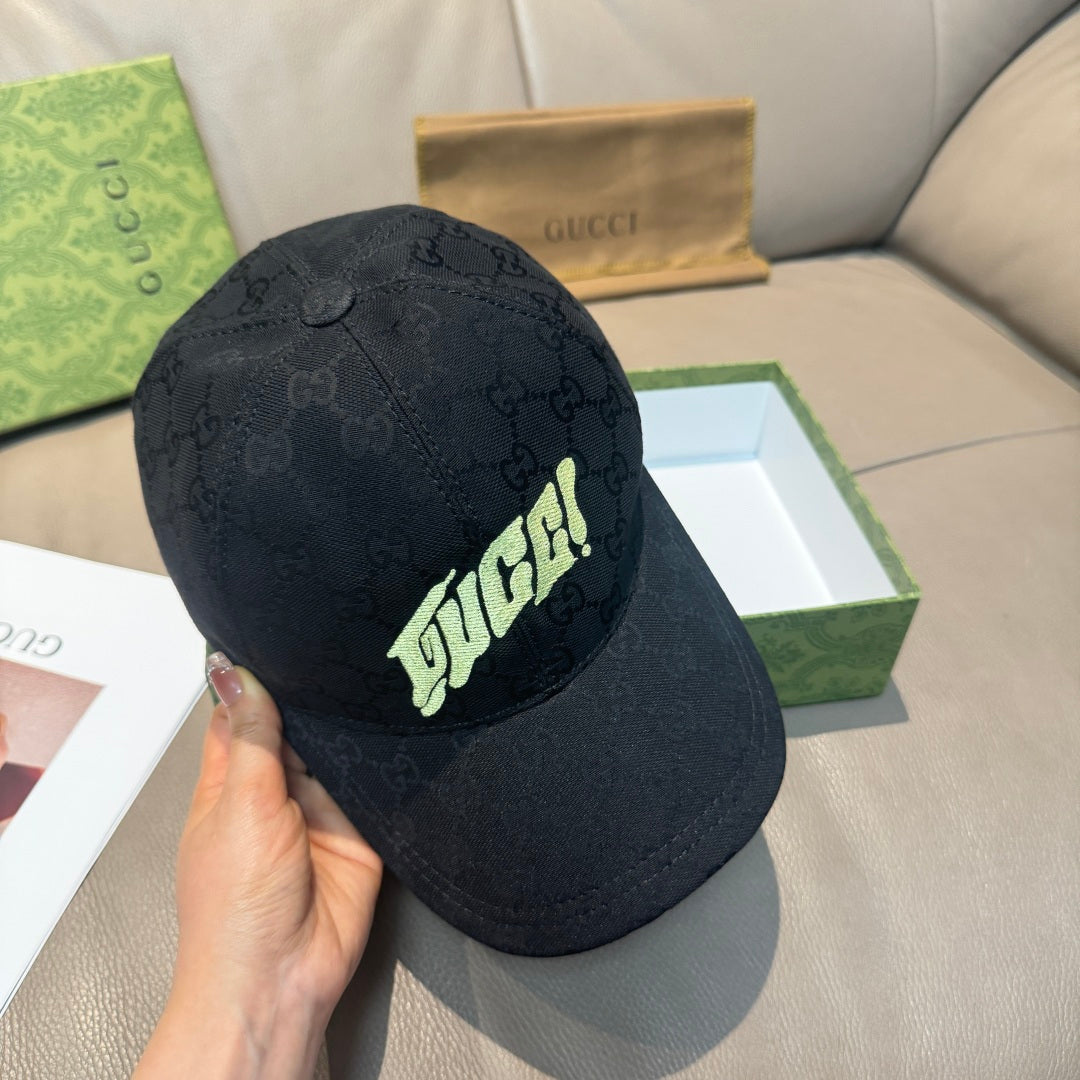 Black Gucci baseball cap held in hand, neon logo front on GG monogram fabric.