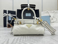 White Prada mini handbag with top handles, gold hardware, and detachable shoulder strap.