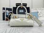 White Prada mini handbag with top handles, gold hardware, and detachable shoulder strap.