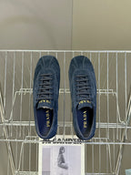 Blue suede sneakers, top view with laces and Prada logo on tongues.