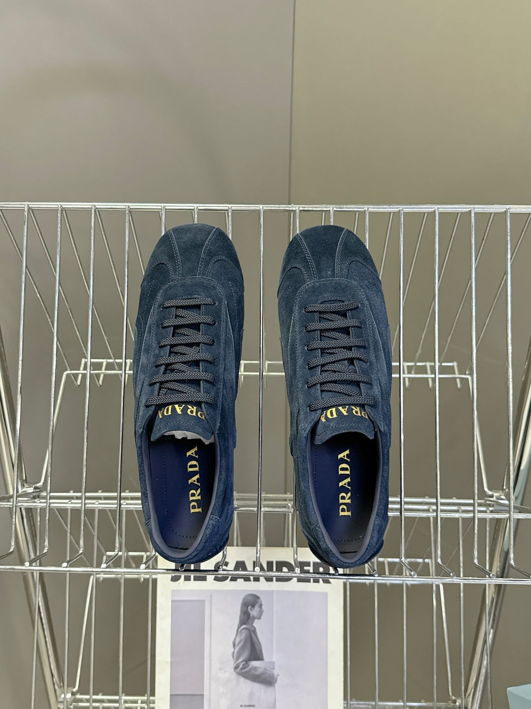 Blue suede sneakers, top view with laces and Prada logo on tongues.