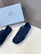 Blue suede sneakers, lace-up design with side logo patches.