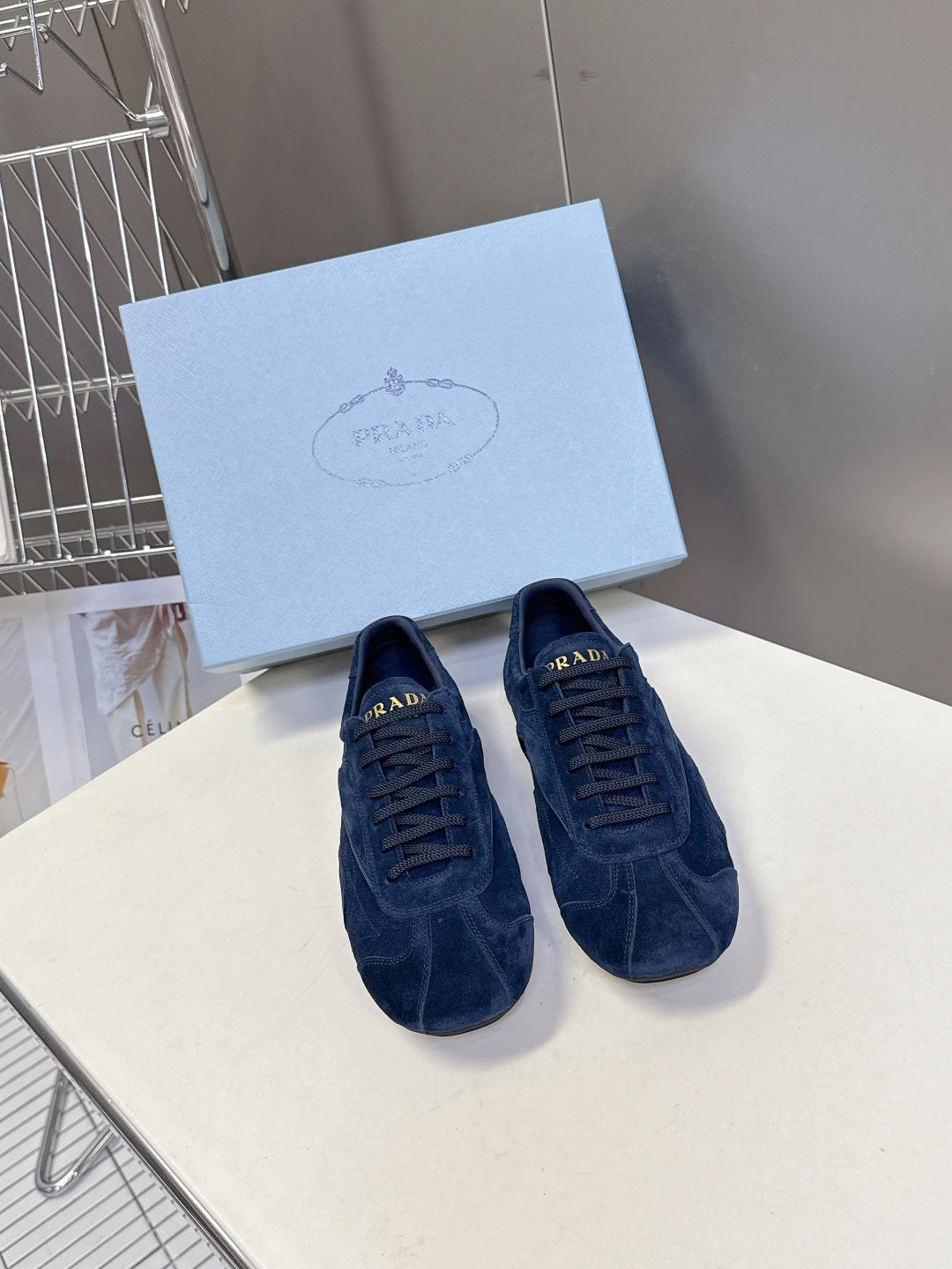 Blue suede sneakers with lace-up closure, Prada logo detail.