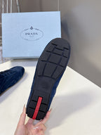 Blue suede sneaker sole with tread pattern and red logo detail.