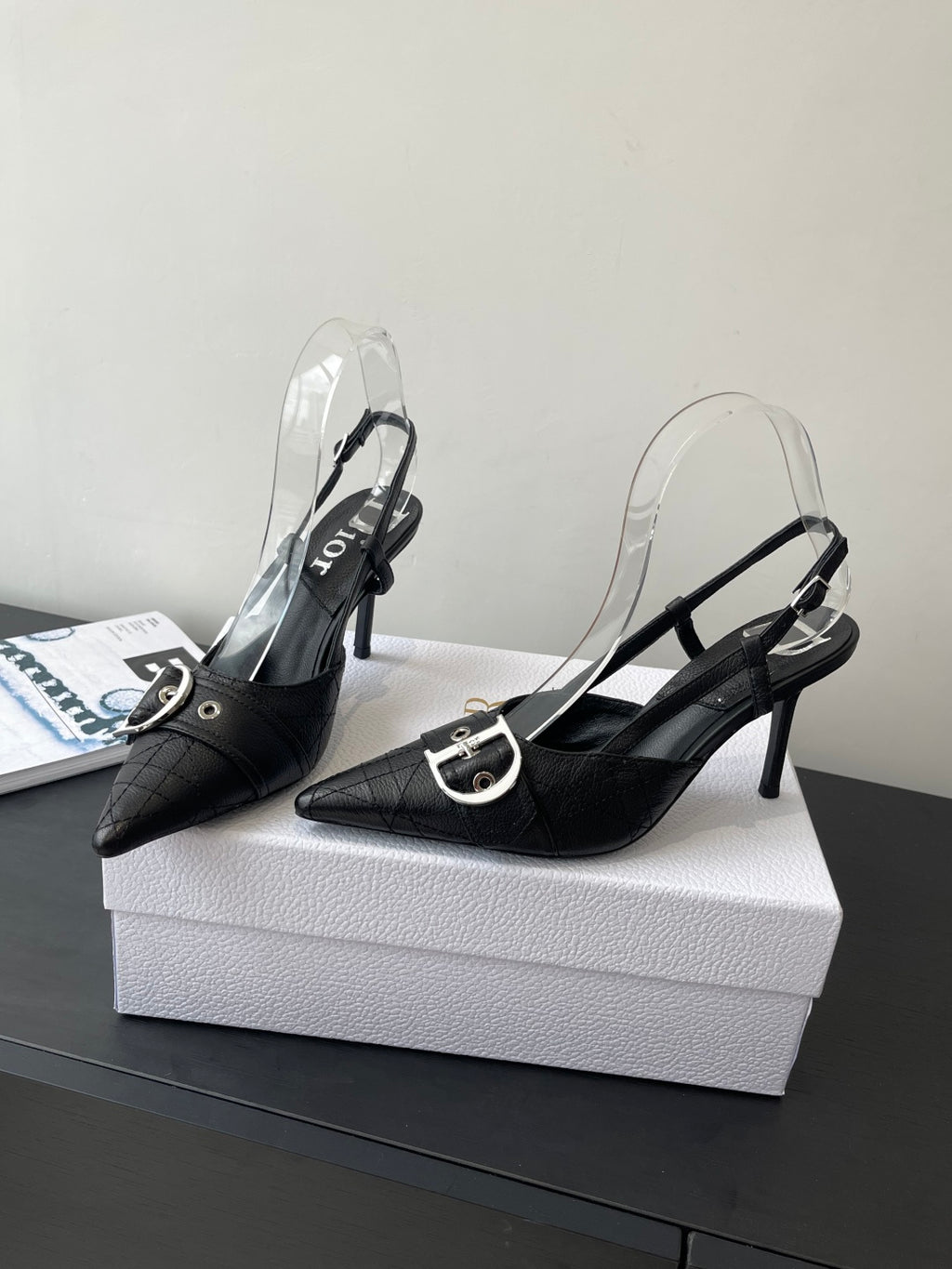 Black pointed-toe slingback pumps with silver buckle strap and stiletto heel pair