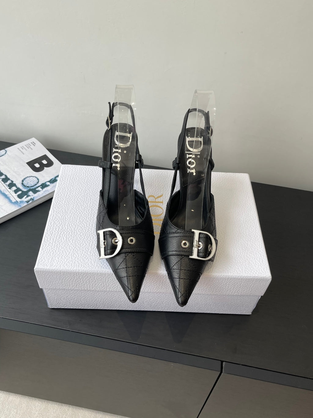Black pointed-toe Dior slingback pumps with buckle strap and stiletto heels