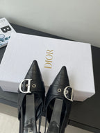 Pair of black pointed-toe slingback pumps with silver buckle and high stiletto heel