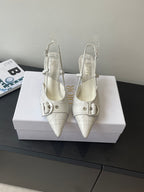Cream leather women’s slingback heels with double buckle straps and pointed toe