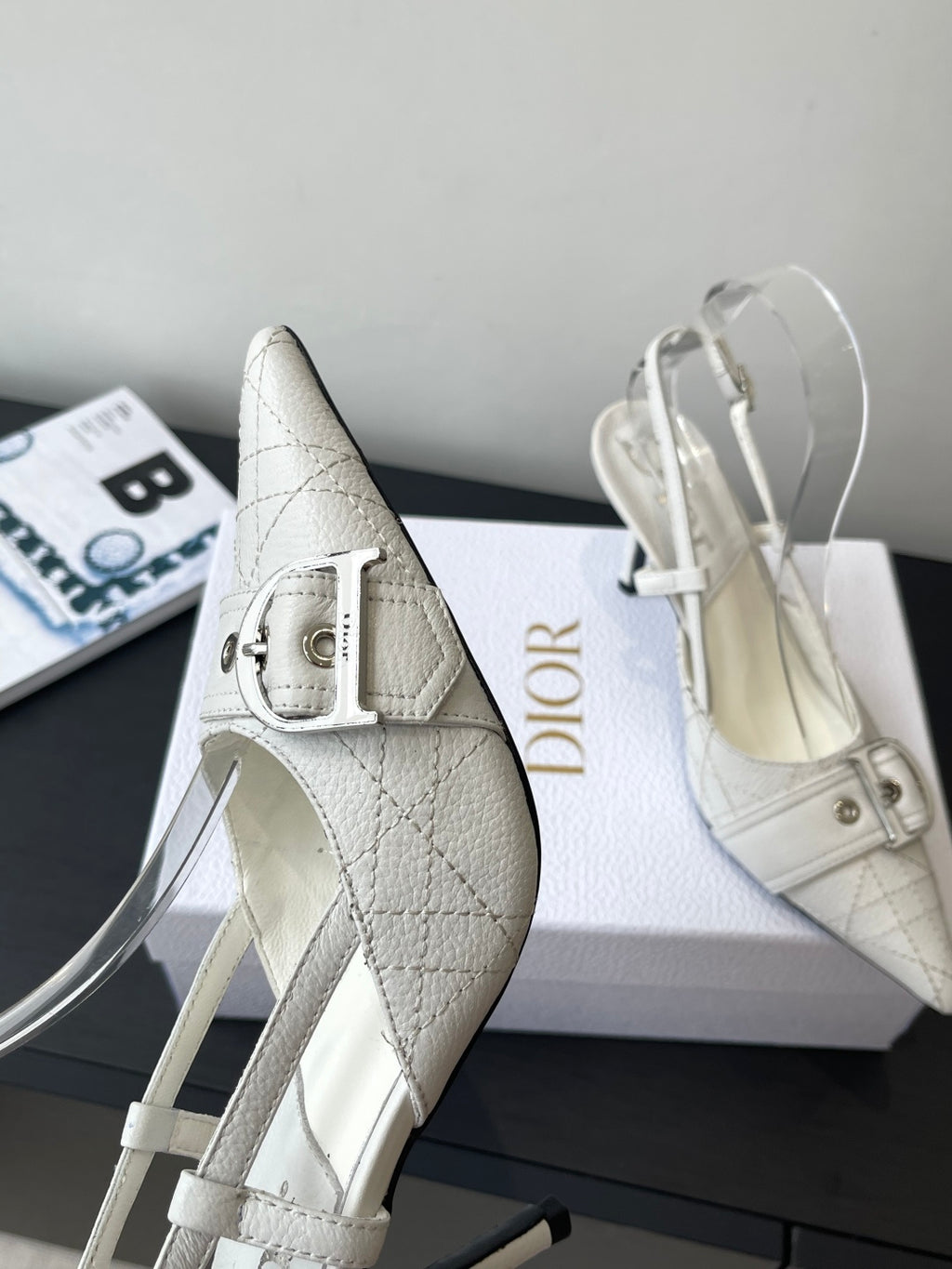 Cream leather pointed-toe slingback heels with metal buckle and high stiletto heel