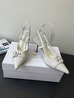 Cream leather women’s slingback heels with pointed toe, ankle strap, and metal buckle