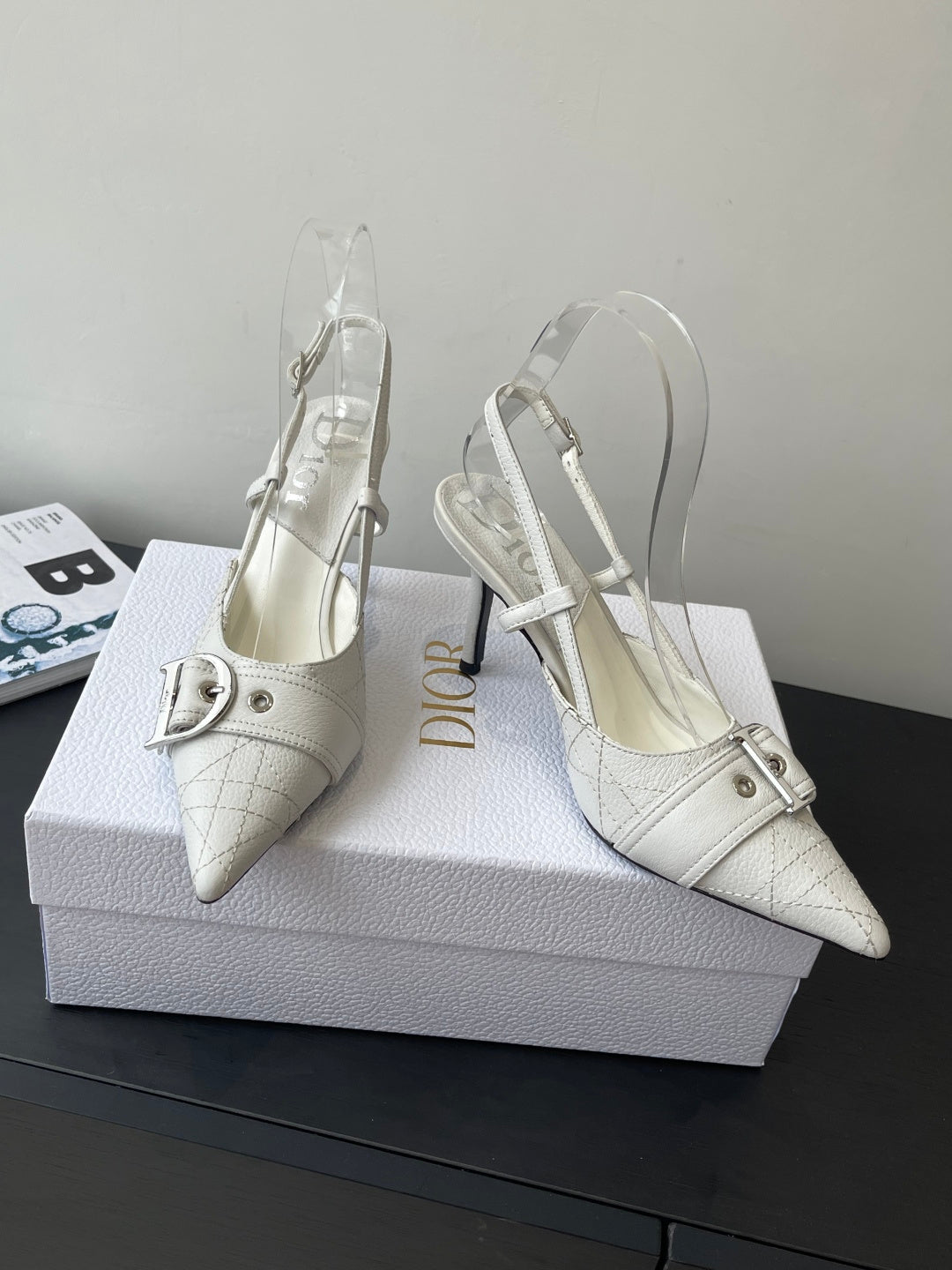 Cream leather women’s slingback heels with pointed toe, ankle strap, and metal buckle