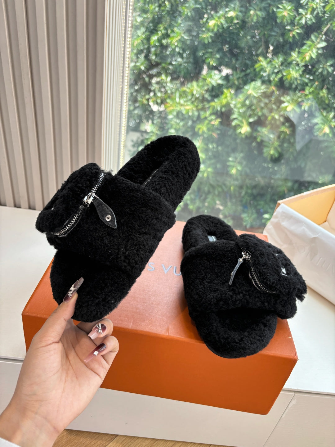 Black fuzzy slip-on sandals with V-logo and small zip pull